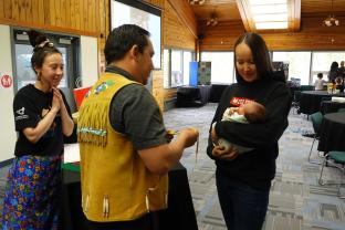 3 people welcoming baby to the community