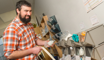 Man taking a low flow shower head from bins of energy efficient items Man taking a low flow shower head from bins of energy efficient items