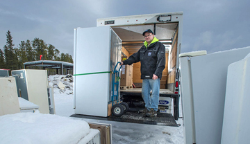 Delivery man picking up old inefficient fridge Delivery man picking up old inefficient fridge