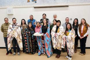 First Nation School Board of Trustees wearing blankets as they are sworn in. 