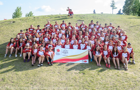 Team Yukon at 2017 Canada Summer Games Image of Team Yukon contingent at 2017 Canada Summer Games. About 100 participants sit on a sunny hill.